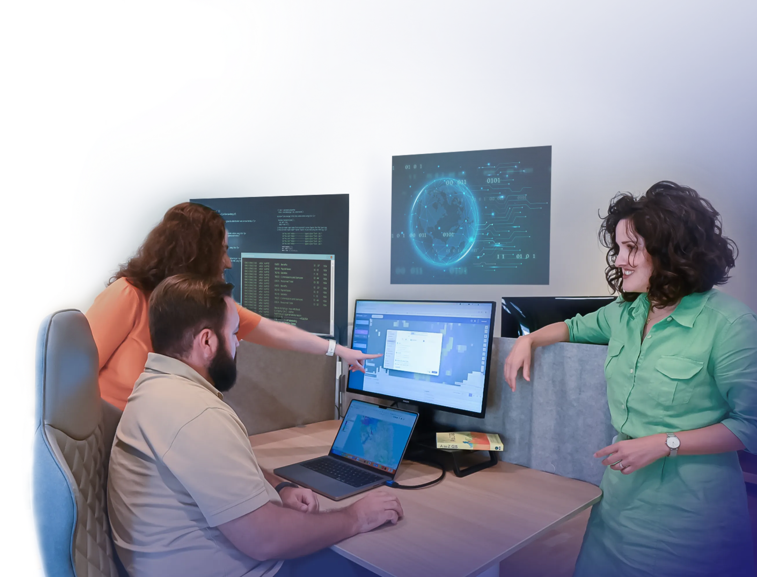 GIS developers smiling and pointing to a computer screen.